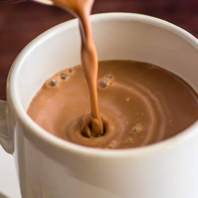 Homemade hot chocolate being poured into a cup.