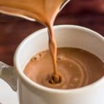 Homemade hot chocolate being poured into a cup.