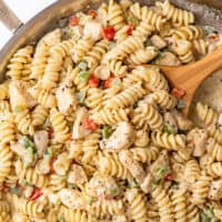 Cucchiaio scavando pasta di pollo cremoso con peperoni.