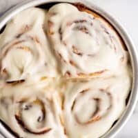 Overhead photo of a small batch of cinnamon rolls with cream cheese frosting in a baking dish.