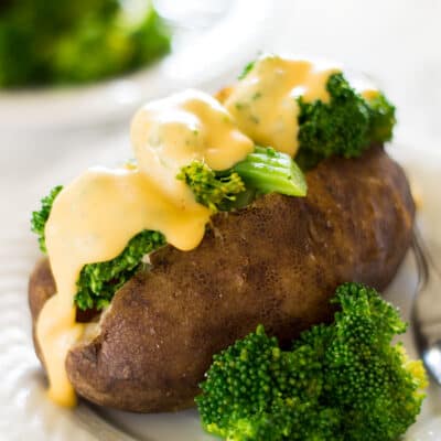 Baked potato topped with broccoli and cheddar cheese sauce.