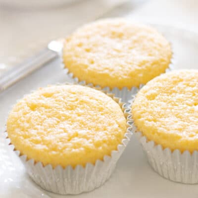 Three cornbread muffins on a white plate.