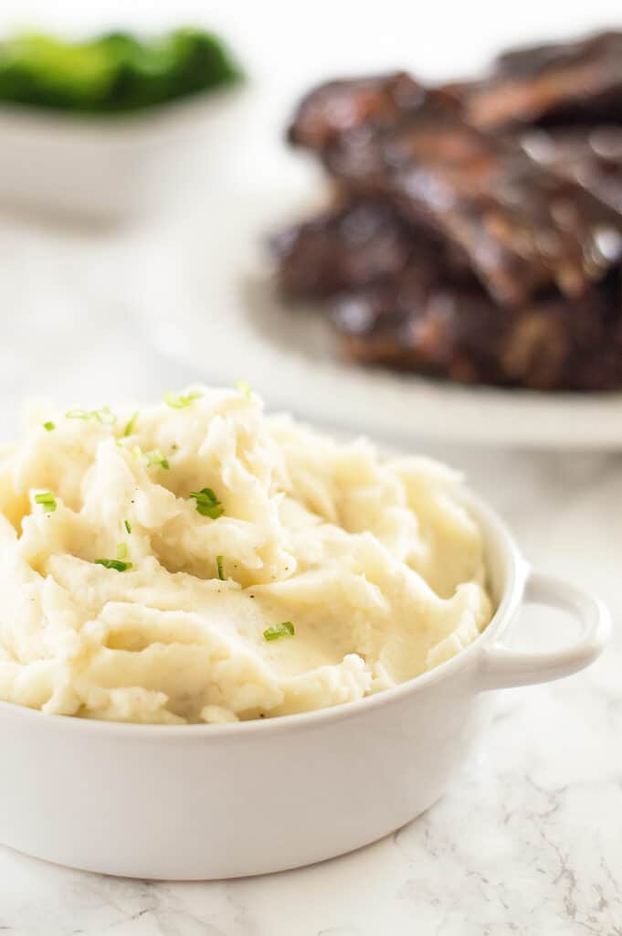 Homemade mashed potatoes on a table with ribs.