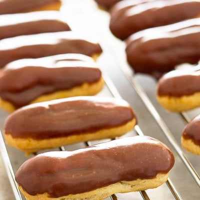 These cute and delicious Mini Pumpkin Eclairs are topped with chocolate glaze and filled with rich pumpkin pastry cream. Recipe includes nutritional information. From BakingMischief.com