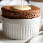Creme anglaise being poured over chocolate souffle.