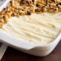 Photo of small carrot cake with cream cheese frosting in a white dish.