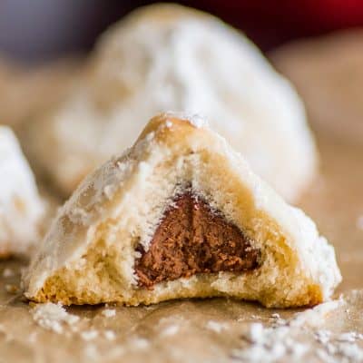 Snowball cookie with chocolate kiss inside with a bit taken out of it.