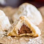 Snowball cookie with chocolate kiss inside with a bit taken out of it.