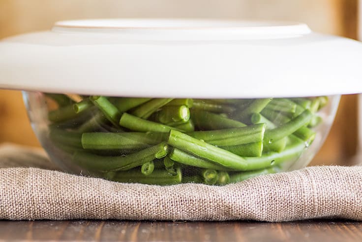 Image of How to Steam Green Beans in the Microwave step 2, green beans in a bowl covered with a plate.