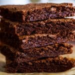 Small batch brownies stacked on parchment paper.