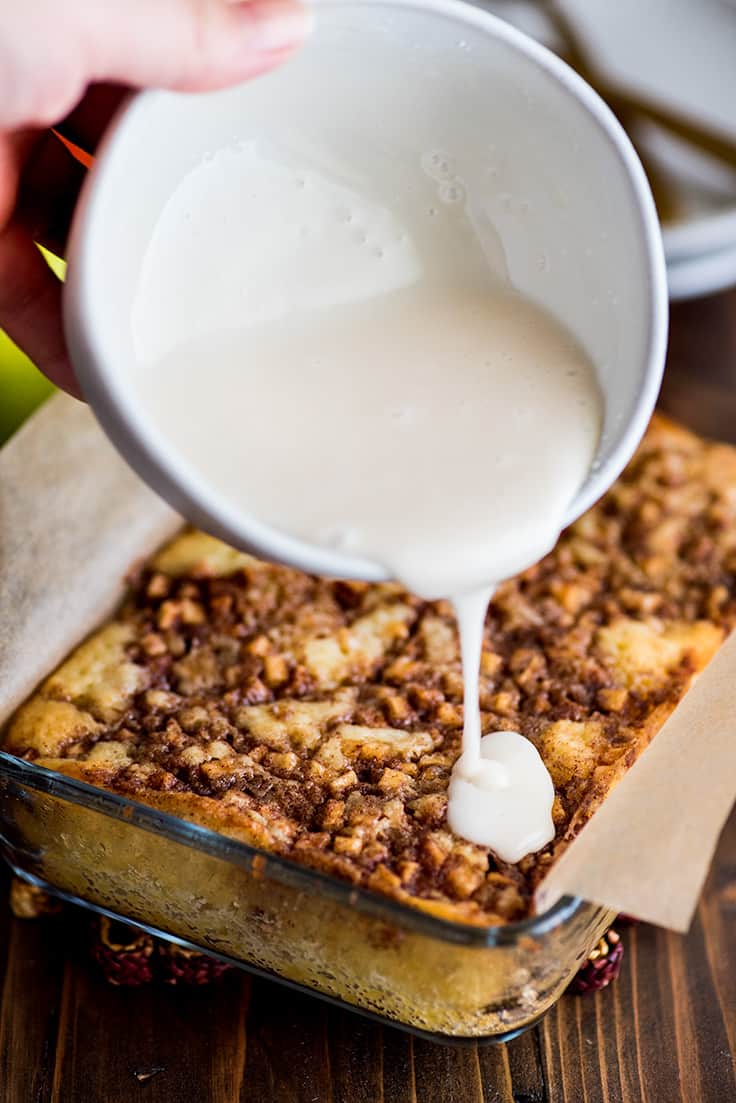 Photo of Small Apple Cinnamon Cake being topped with powdered sugar glaze.