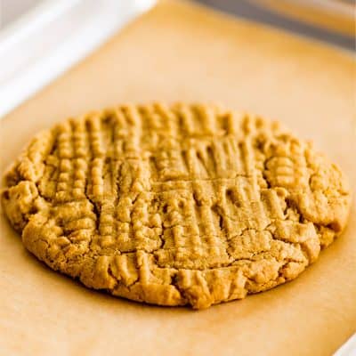 Picture of giant one peanut butter cookie on a quarter sheet baking tray.