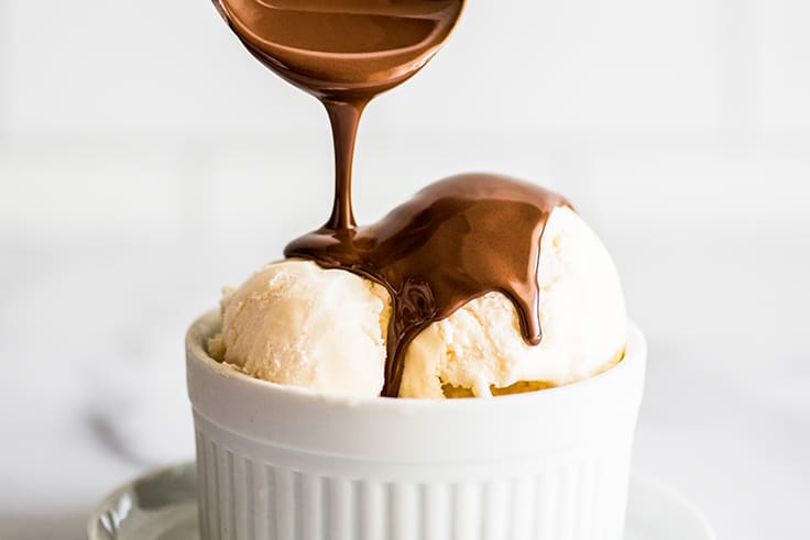 Chocolate shell being poured over ice cream.