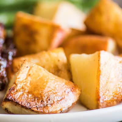 Oven-roasted red potatoes on a white plate.