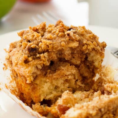 Cinnamon Apple Crumb Muffin on a plate split in half.