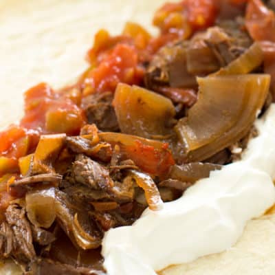 Beef fajitas on a white plate.