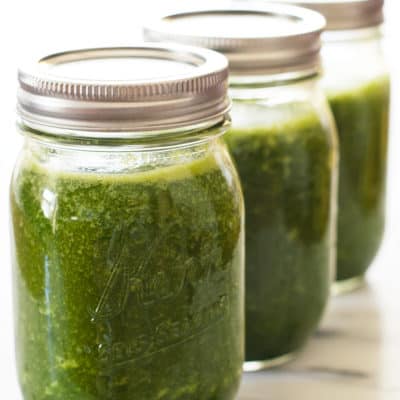 Three green smoothies in mason jars.