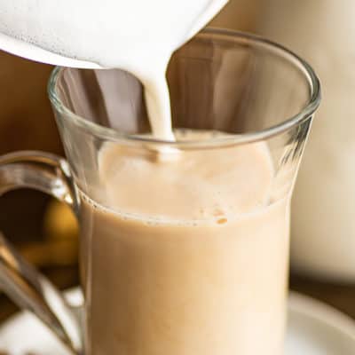 Frothed milk being poured into a chai tea latte.