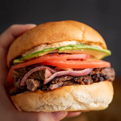 Hand holding a Carne Asada Sandwich