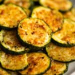 Close up photo of baked parmesan zucchini on a plate.