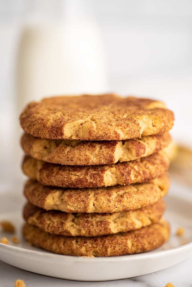 Pumpkin snickerdoodles stacked on a plate.