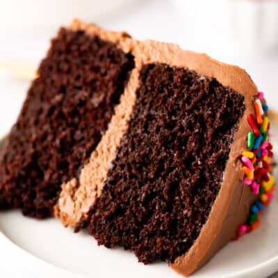 Slice of a small chocolate layer cake on a plate.