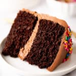 Slice of a small chocolate layer cake on a plate.