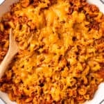 American goulash with cheese in a white Dutch oven.