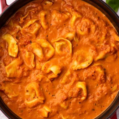 Tomato soup with tortellini in a red Dutch oven.