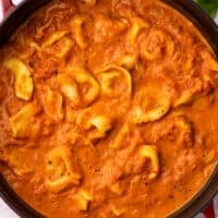 Tomato tortellini soup in a red Dutch oven.
