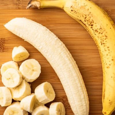 Bananas on a cutting board being prepped for freezing.