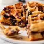 Blueberry waffle pieces on a white plate.