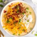 Potato bacon soup in a white bowl.