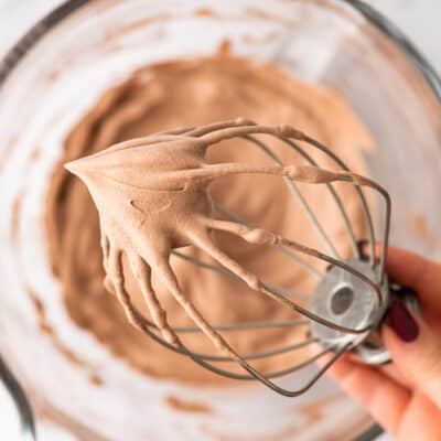 Whisk attachment with chocolate whipped cream on it.