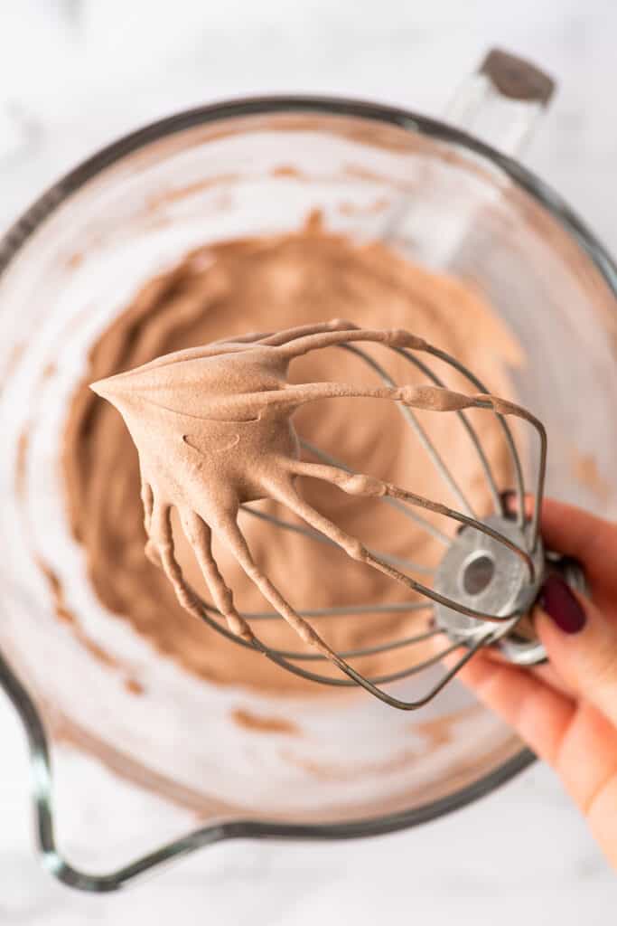 Whisk attachment with chocolate whipped cream on it.