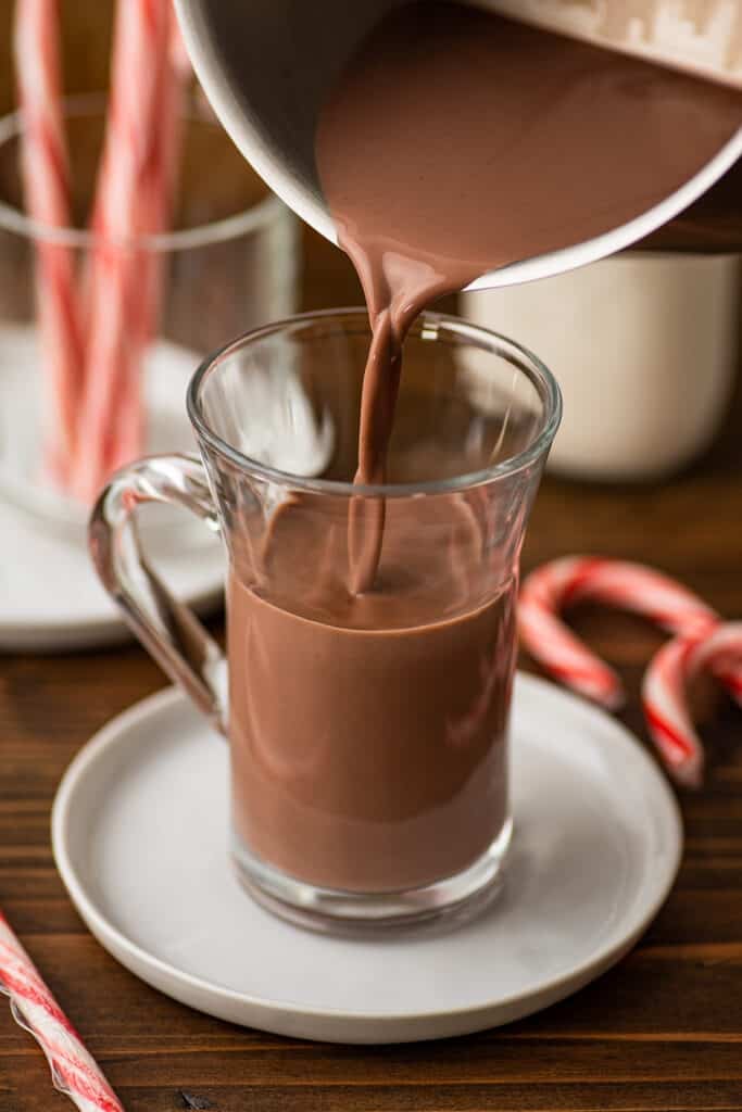 Peppermint hot chocolate being poured into a mug.