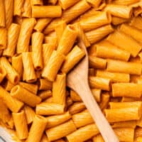 Spoon scooping pasta in vodka sauce.