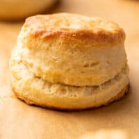 Cream biscuit sitting on parchment paper.