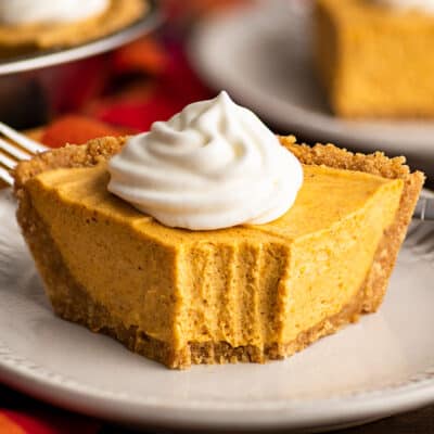 Slice of no-bake pumpkin cheesecake with a bite out of it.