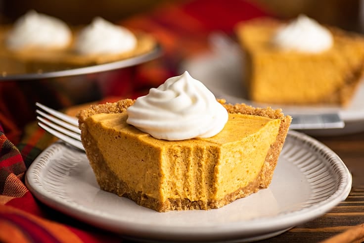 Slice of no-bake pumpkin cheesecake with a bite out of it.