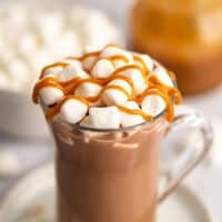 Salted caramel hot chocolate in a mug with marshmallows and caramel drizzle.