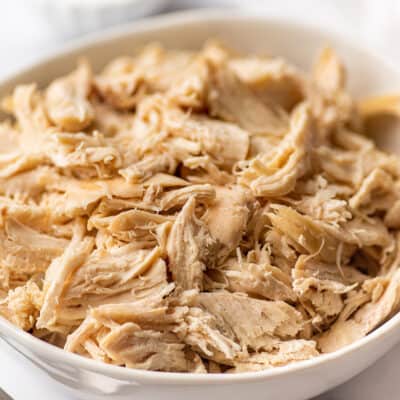 Shredded chicken for recipes in a white bowl.