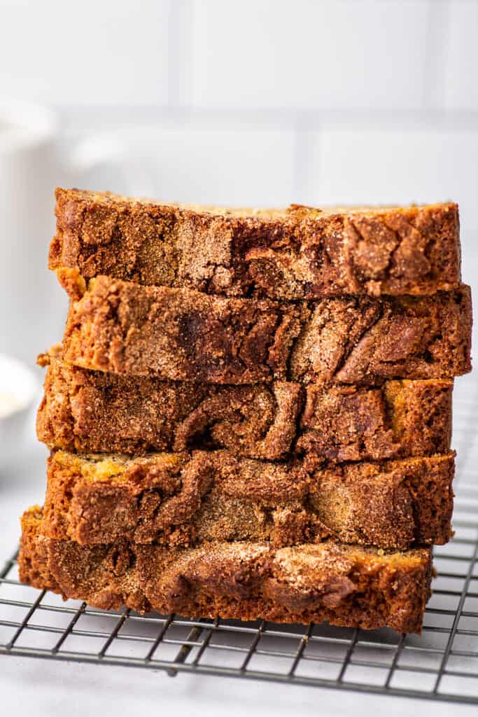 Slices of banana bread stacked on a cooking rack.