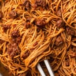 close up shot of a bolognese with some bolognese wrapped around tongs
