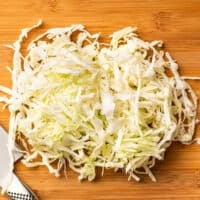 Shredded cabbage on a cutting board.