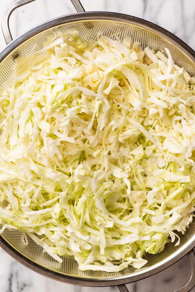 Shredded cabbage in a colander.