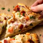 Slice of chicken bacon ranch pizza being picked up.