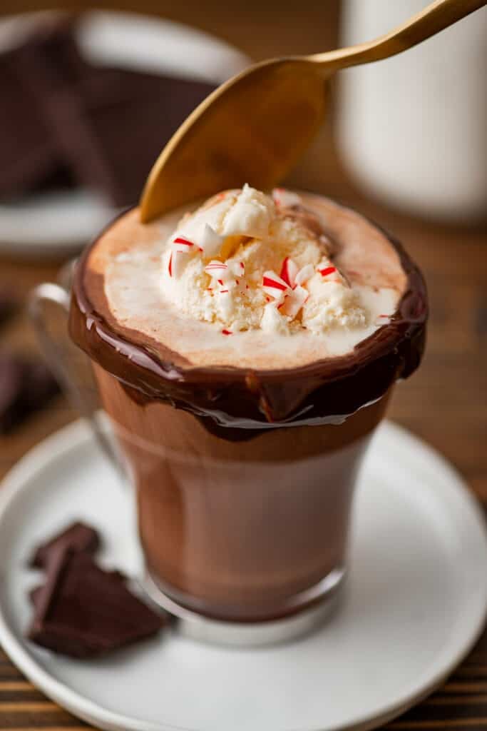 Spoon scooping ice cream out of hot chocolate.
