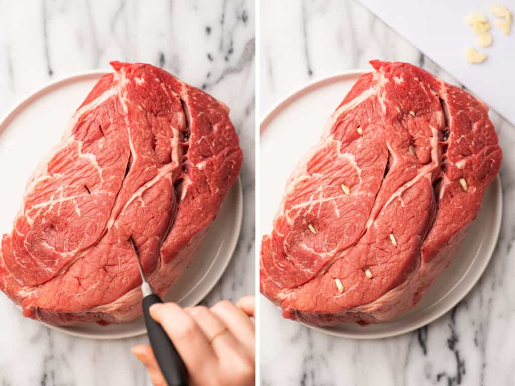 Pot roast being stuffed with garlic.