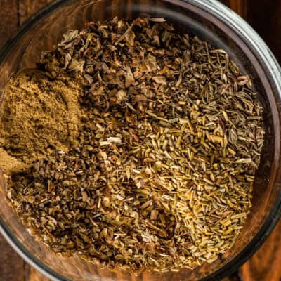 a bowl of homemade italian seasoning with a teaspoon